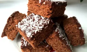 En hög med saftiga glutenfria mockarutor, toppade med chokladglasyr och kokosflingor. Perfekt för fikat!