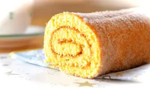 En saftig glutenfri rulltårta med sockerströssel, perfekt för fikat.