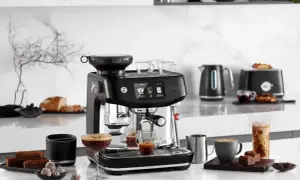 Svart espressomaskin med kaffekoppar, chokladbitar och en glasburk med iskaffe. Perfekt för att brygga gott kaffe oavsett om du har hårt eller mjukt vatten.