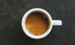 En vit kopp med en gyllene espresso, en perfekt start på dagen med äkta italienska kaffesorter.