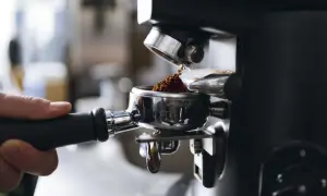 Malet kaffe fyller portafiltret, redo för att brygga en kopp av det dyraste kaffet djur kan producera.