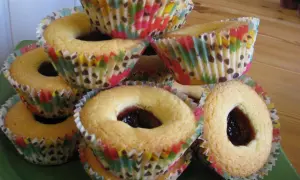 En hög med hallongrottor i färgglada muffinsformar, redo att avnjutas.