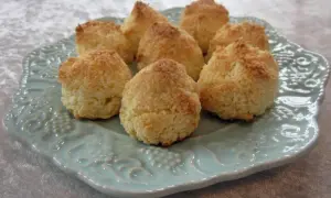En tallrik med nybakade kokostoppar, perfekta för ett enkelt kokostoppar recept. De gyllene topparna ser inbjudande ut.