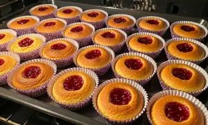 Nybakade hallongrottor i sina lila formar, redo att avnjutas. Ett perfekt hallongrottor recept för fikat.