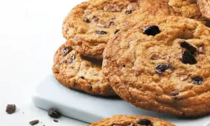 En hög med gyllene, glutenfria chocolate chip cookies, perfekta för en fika.