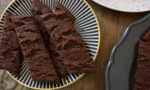 Chokladsnittar med flingsalt på en svartvitrandig tallrik. Dessa sega och rika chokladkakor är perfekta för fikat.