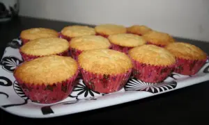 En bricka med gyllene muffins i rosa formar. Ett perfekt semper fin mix recept för fikat.