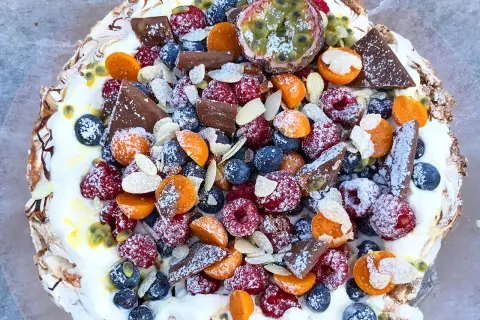En vacker pavlova med bär, choklad och passionsfrukt. Ett perfekt pavlova recept för sommaren.