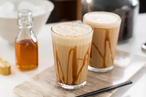 Två glas med karamellfrappé, redo att avnjutas. Ett enkelt frappe recept för en varm sommardag.