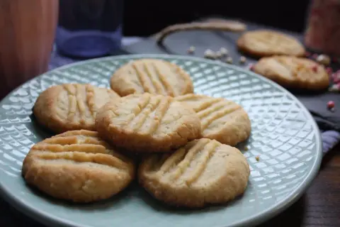 En tallrik med gammaldags gaffelkakor, gyllene och inbjudande, redo att avnjutas.