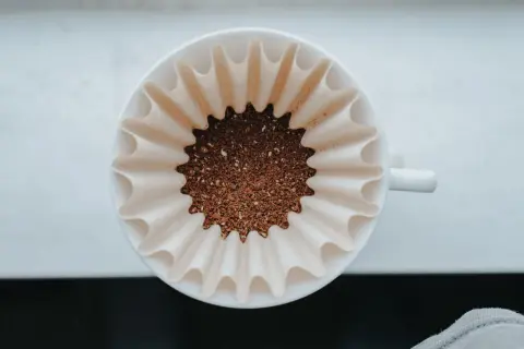 Färskt kaffepulver i ett filter, redo att bryggas. En perfekt kaffesked mått för morgonens njutning.