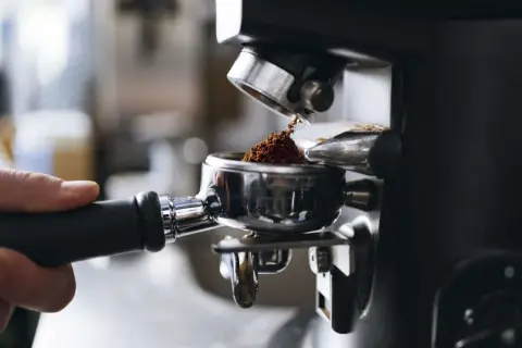 Malet kaffe fyller portafiltret, redo för att brygga en kopp av det dyraste kaffet djur kan producera.