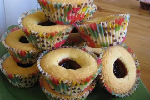 En hög med hallongrottor i färgglada muffinsformar, redo att avnjutas.