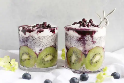 Två glas med chiapudding, kiwi och blåbär. Ett perfekt chiapudding recept för en hälsosam frukost eller mellanmål.