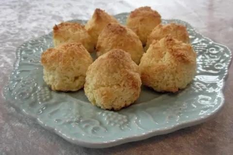 En tallrik med nybakade kokostoppar, perfekta för ett enkelt kokostoppar recept. De gyllene topparna ser inbjudande ut.