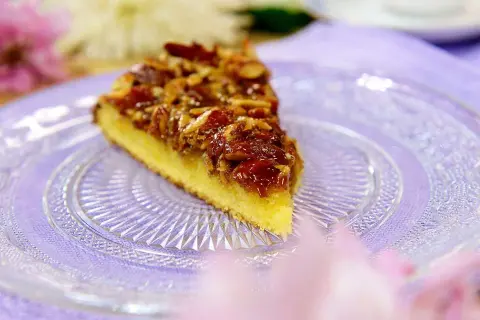 En bit glutenfri toscakaka med mandeltosca på en vacker glasfat.