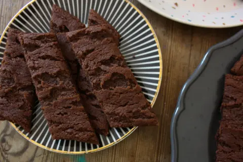 Chokladsnittar med flingsalt på en svartvitrandig tallrik. Dessa sega och rika chokladkakor är perfekta för fikat.