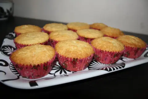 En bricka med gyllene muffins i rosa formar. Ett perfekt semper fin mix recept för fikat.