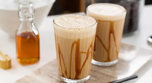 Två glas med karamellfrappé, redo att avnjutas. Ett enkelt frappe recept för en varm sommardag.