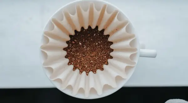 Färskt kaffepulver i ett filter, redo att bryggas. En perfekt kaffesked mått för morgonens njutning.