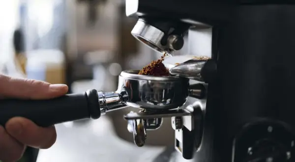 Malet kaffe fyller portafiltret, redo för att brygga en kopp av det dyraste kaffet djur kan producera.