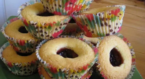 En hög med hallongrottor i färgglada muffinsformar, redo att avnjutas.