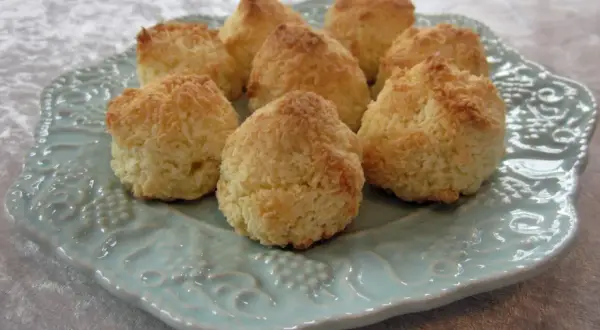 En tallrik med nybakade kokostoppar, perfekta för ett enkelt kokostoppar recept. De gyllene topparna ser inbjudande ut.