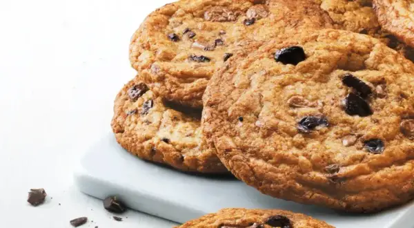 En hög med gyllene, glutenfria chocolate chip cookies, perfekta för en fika.