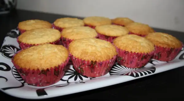 En bricka med gyllene muffins i rosa formar. Ett perfekt semper fin mix recept för fikat.