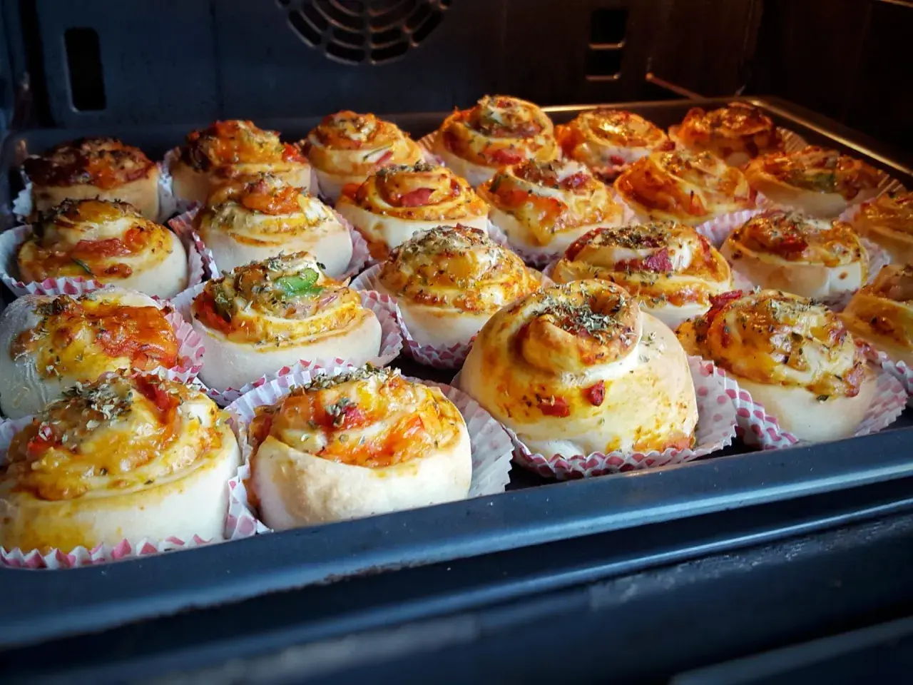 Nybakade pizzabullar i ugnen, redo att avnjutas. Ett perfekt pizzabullar recept för hela familjen.