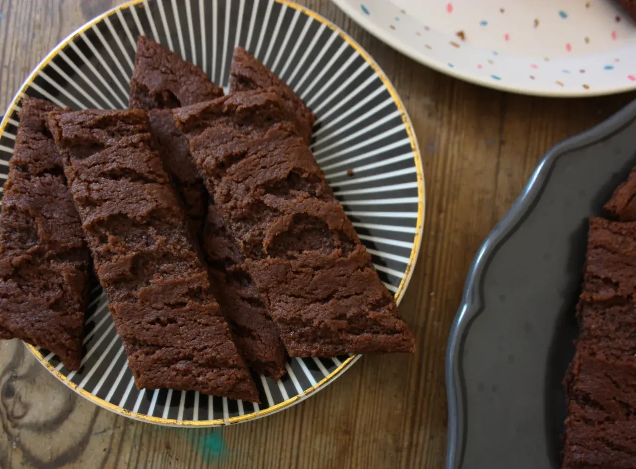 Chokladsnittar med flingsalt på en svartvitrandig tallrik. Dessa sega och rika chokladkakor är perfekta för fikat.