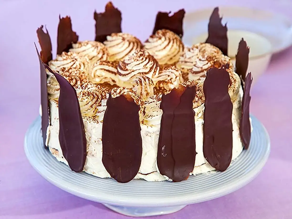 En läcker Schwarzwaldtårta glutenfri med vispgrädde, chokladspån och kakaopulver. Perfekt för alla chokladälskare!