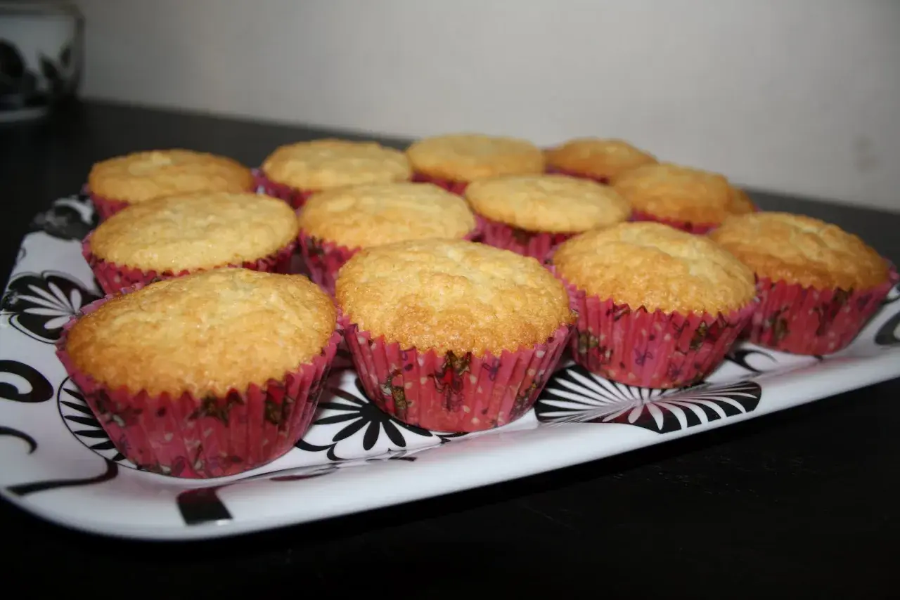 En bricka med gyllene muffins i rosa formar. Ett perfekt semper fin mix recept för fikat.