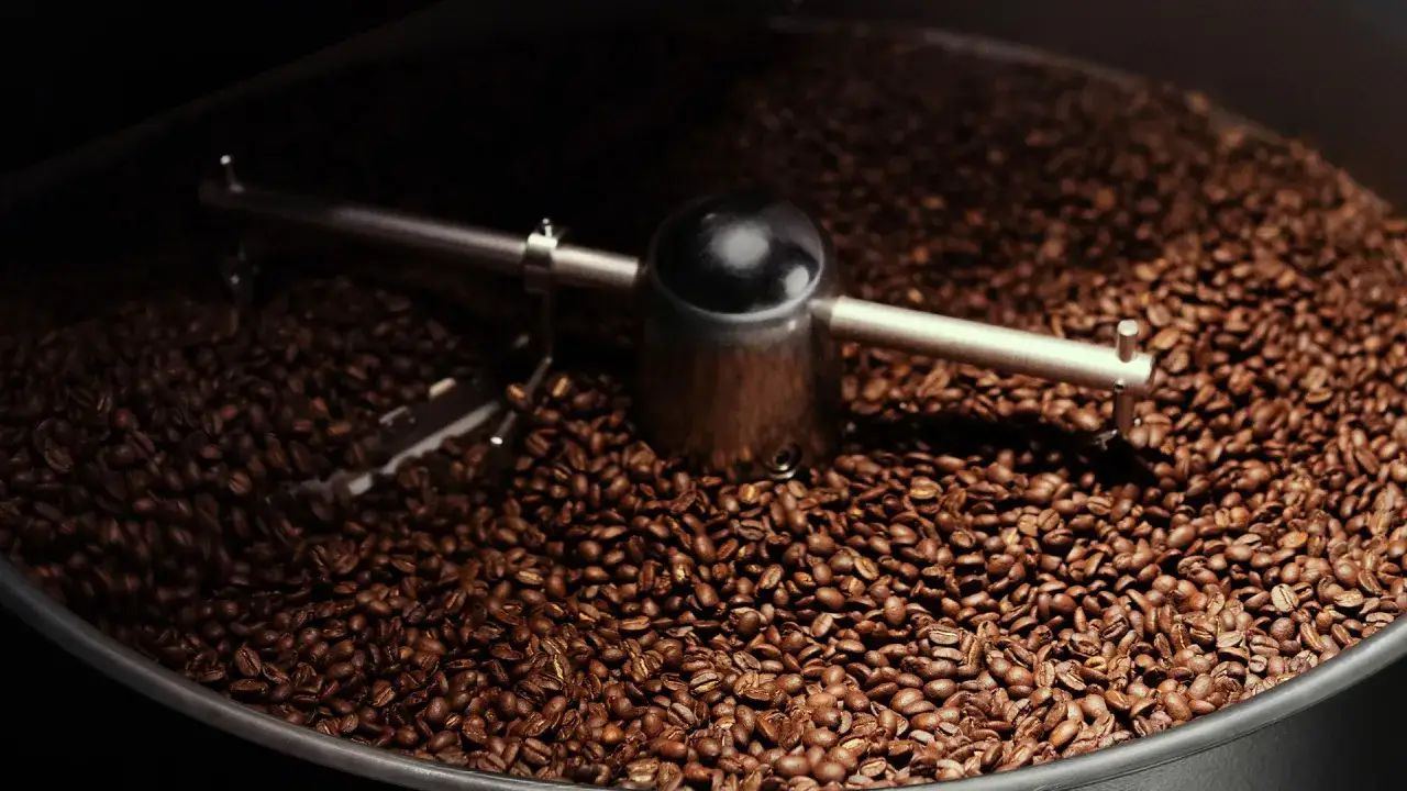 Rostade kaffeb&ouml;nor i en trumma, redo att mala eget kaffe f&ouml;r en perfekt kopp.