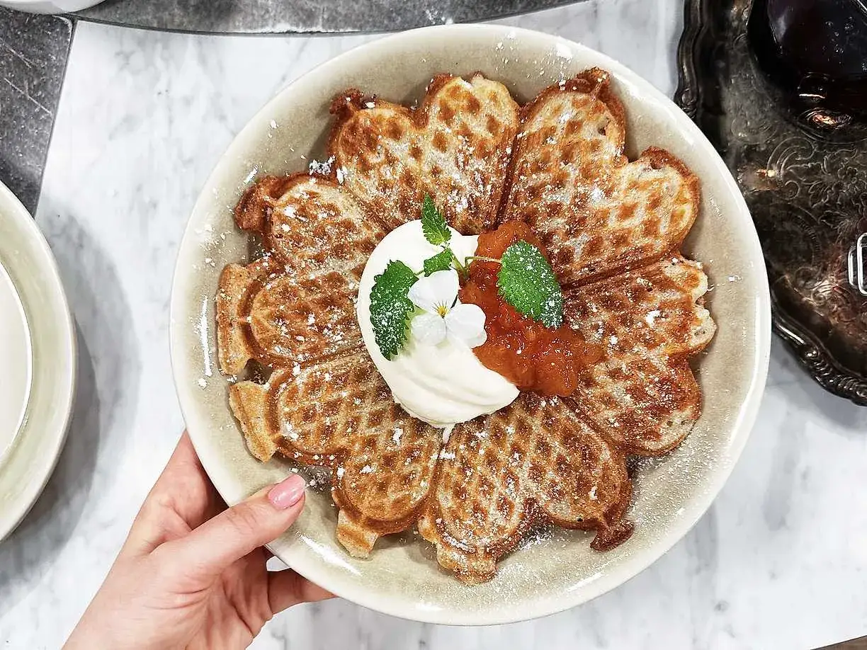 En vacker blomma av glutenfria våfflor maizena, toppad med grädde, sylt och mynta. Perfekt för en fika!