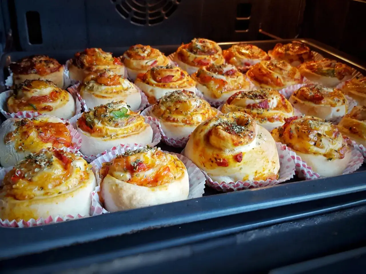 Nybakade pizzabullar med ost och grönsaker, redo att avnjutas. Ett perfekt pizzabullar recept för hela familjen.