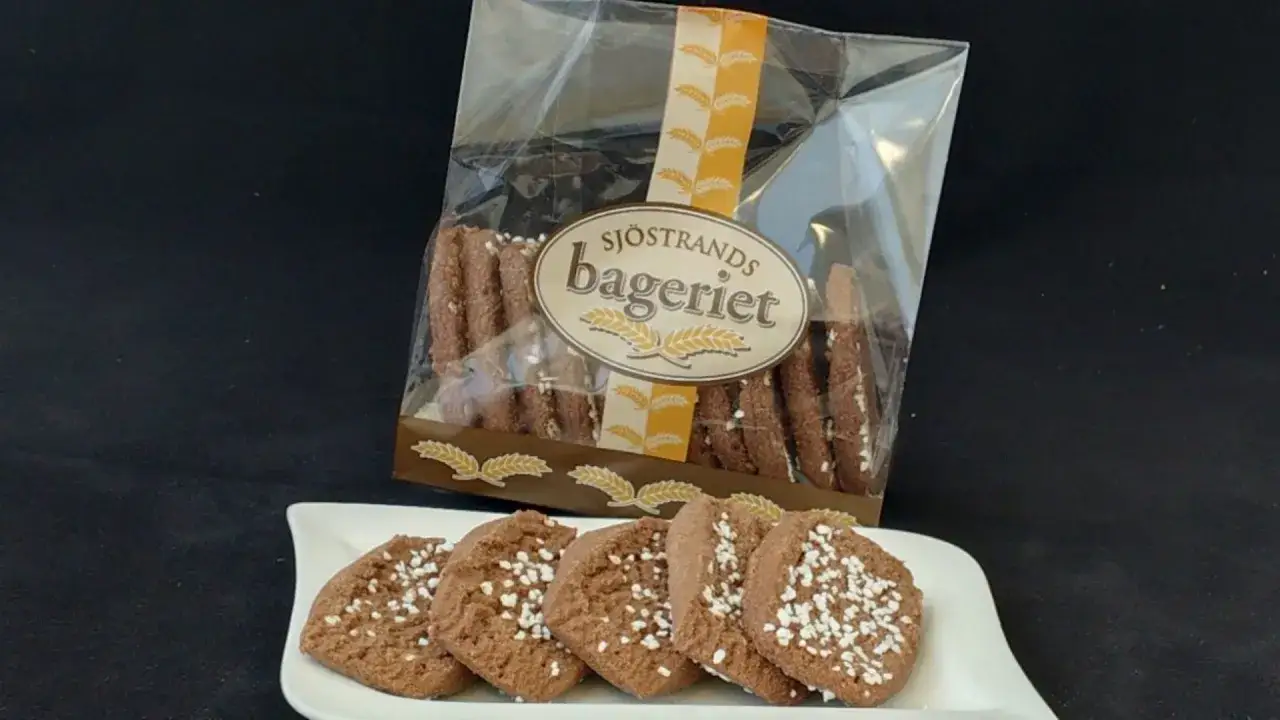 Choklad snittar fr&aring;n Sj&ouml;strands bageri, toppade med p&auml;rlsocker, ligger p&aring; en vit tallrik.