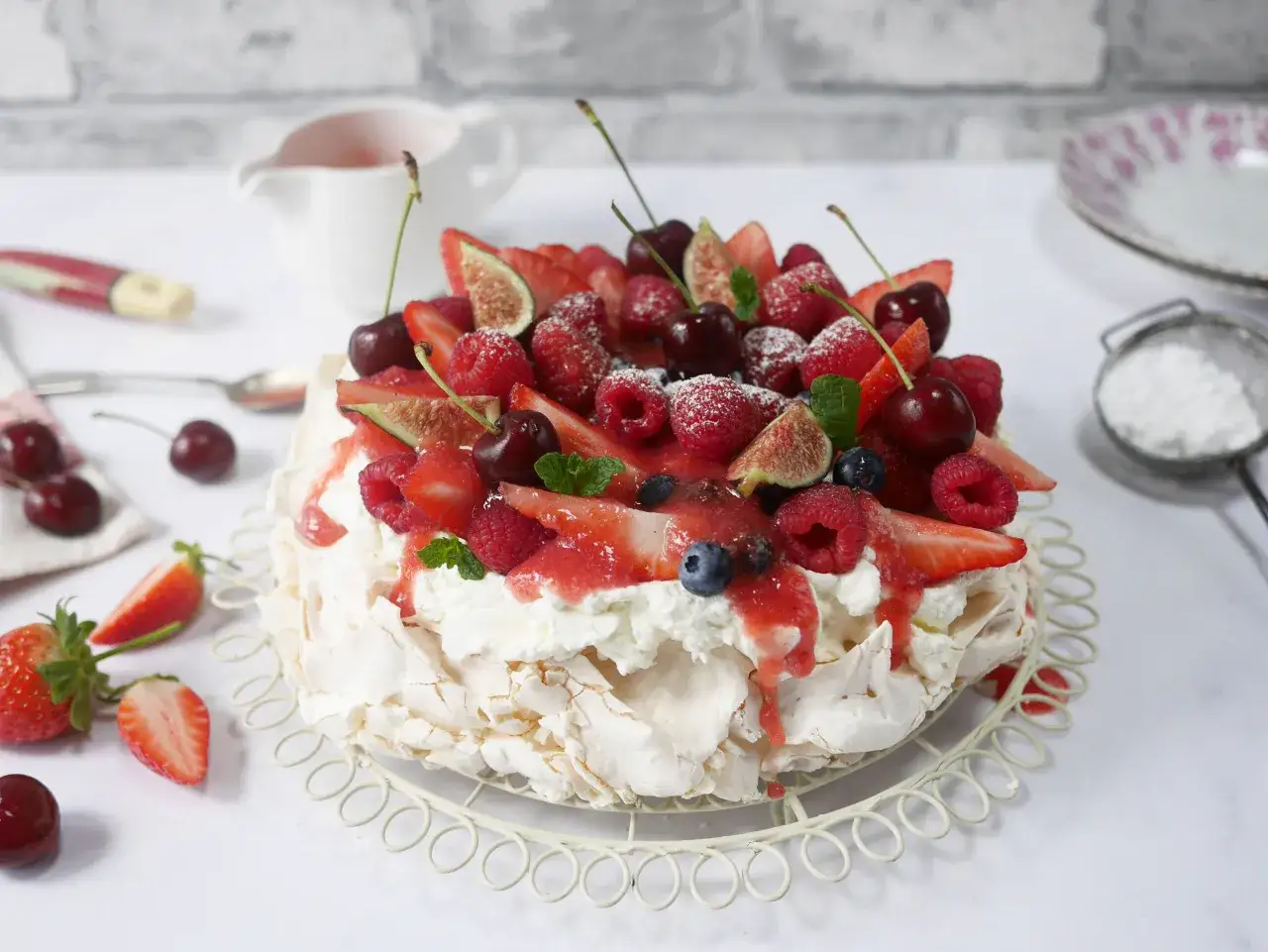 En vacker pavlova med grädde och färska bär, perfekt för ett sommarfika. Detta pavlova recept är en dröm!