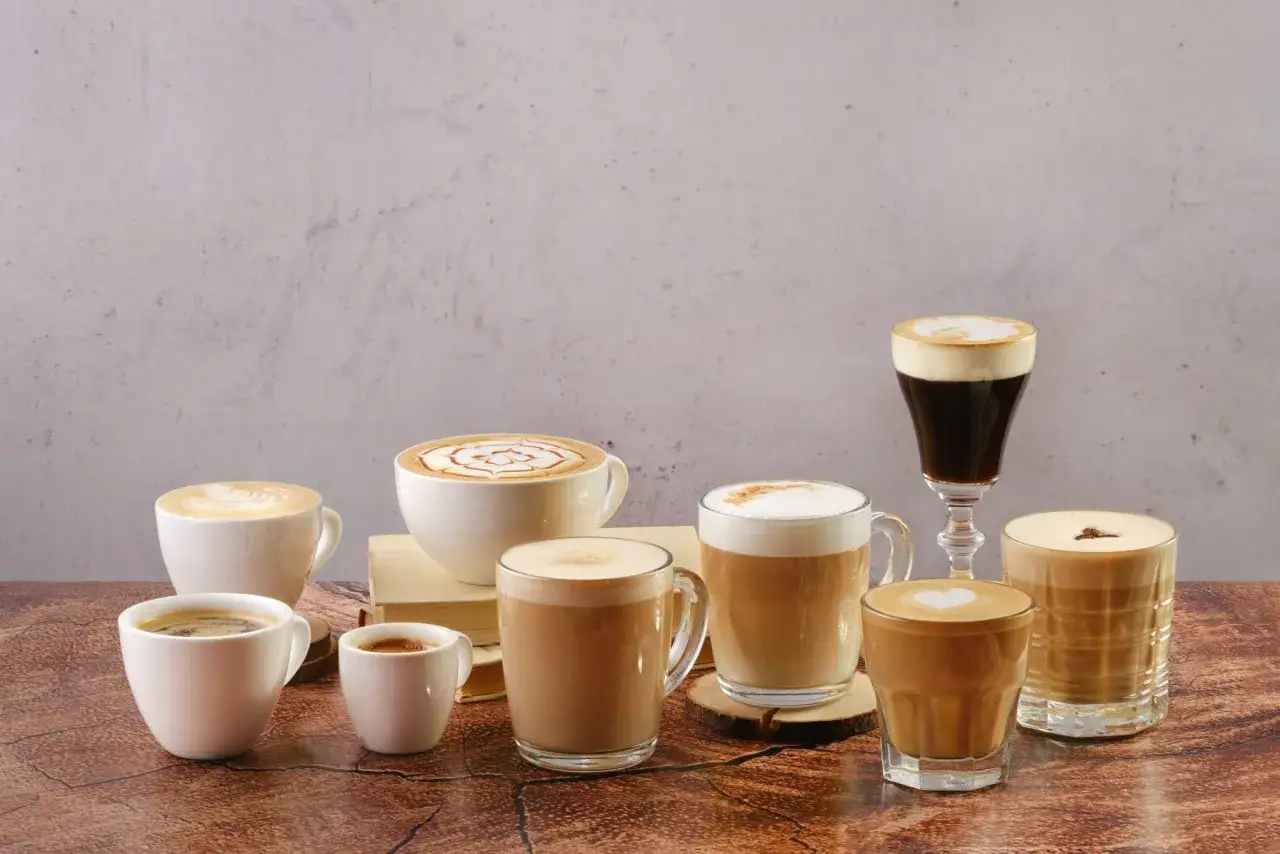 En samling av olika italienska kaffesorter, fr&aring;n espresso till latte, serverade i vackra koppar och glas.