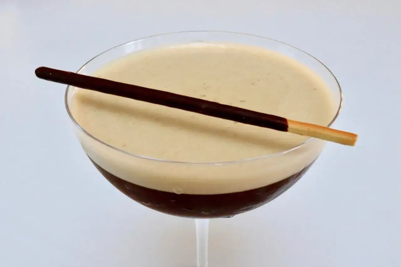 En krämig espresso martini med en chokladtäckt kexpinne som dekoration.