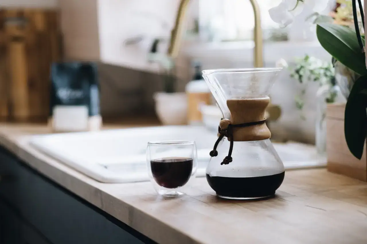 En Chemex med f&auml;rdigbryggt, starkt bryggkaffe bredvid ett glas. Morgonritualen &auml;r komplett.