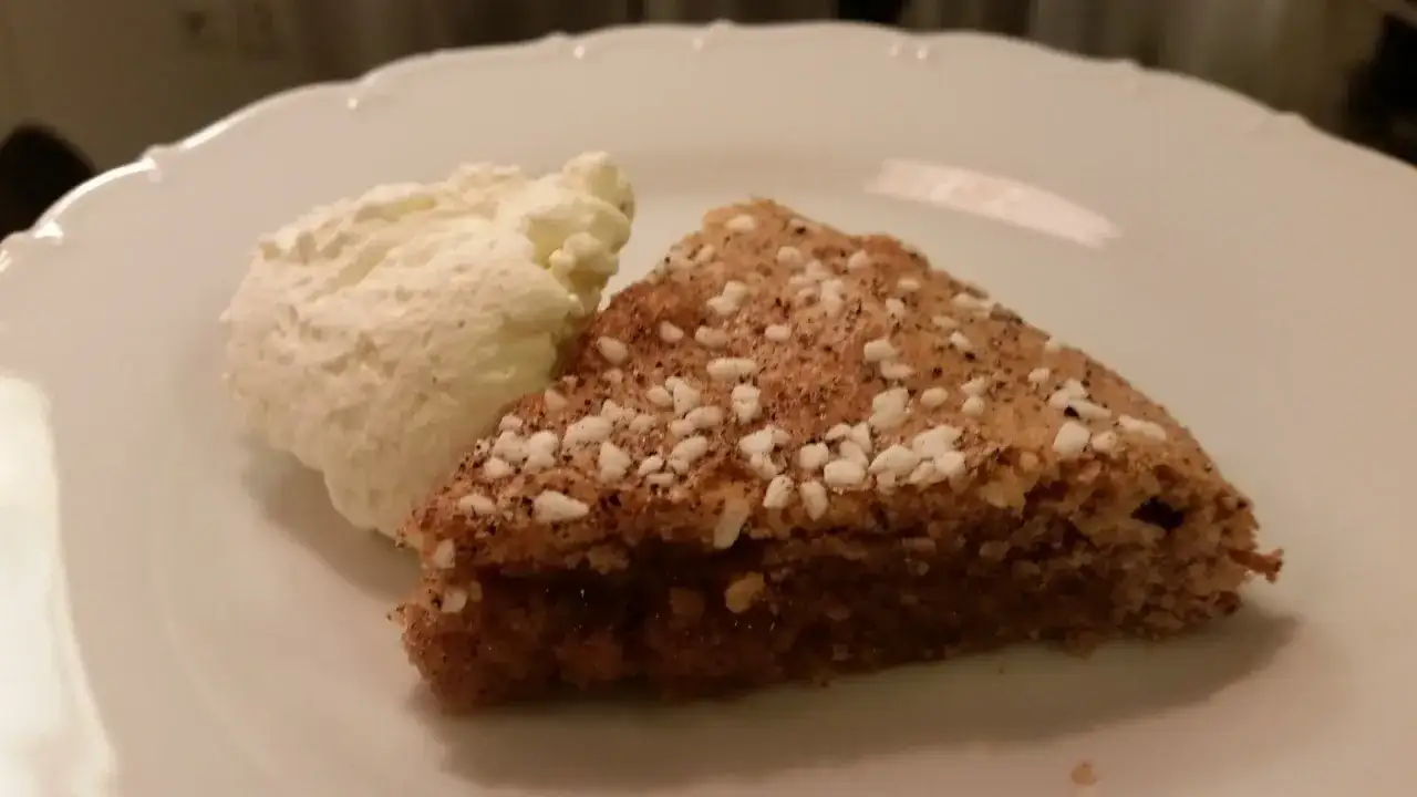En bit glutenfri kanelbullekladdkaka med en klick vispad gr&auml;dde.