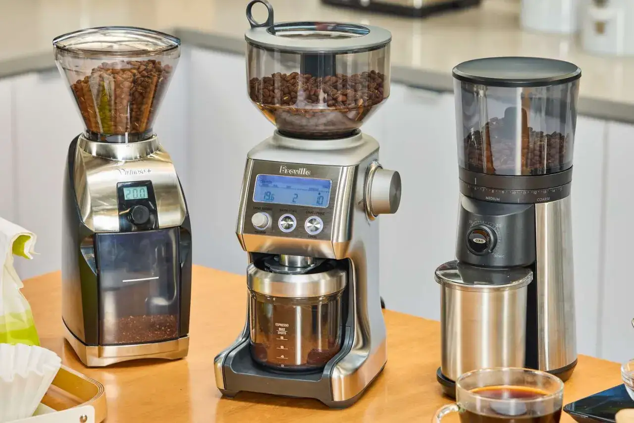 Tre kaffekvarnar redo att mala färskt kaffe till espressomaskinen. En kopp kaffe står redo.