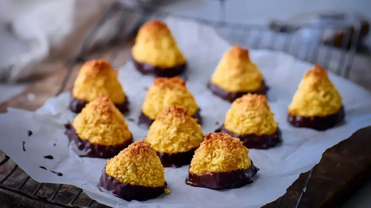 Små, gyllene kokostoppar med chokladbotten, perfekta för ett enkelt kokostoppar recept.