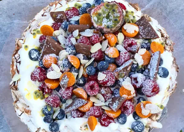 En vacker pavlova med bär, choklad och passionsfrukt. Ett perfekt pavlova recept för sommaren.
