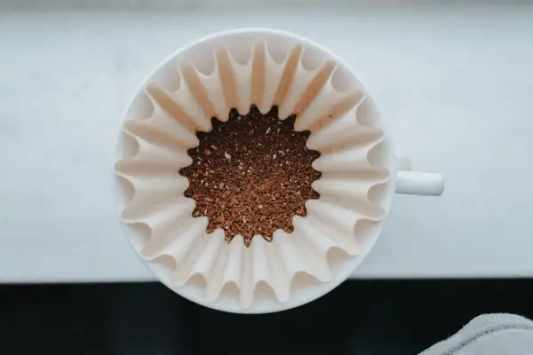 Färskt kaffepulver i ett filter, redo att bryggas. En perfekt kaffesked mått för morgonens njutning.