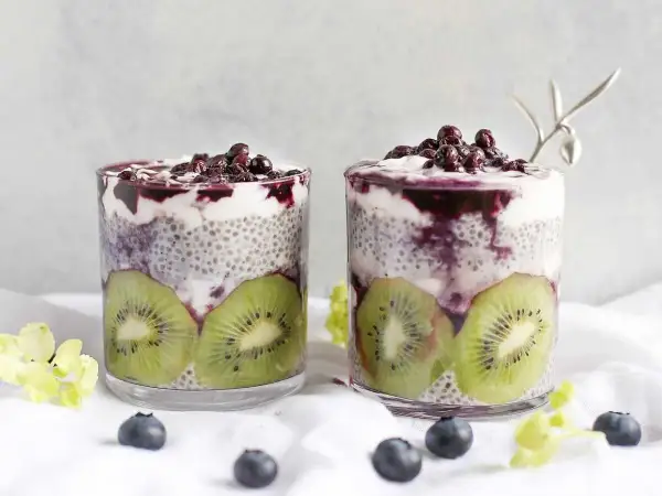 Två glas med chiapudding, kiwi och blåbär. Ett perfekt chiapudding recept för en hälsosam frukost eller mellanmål.