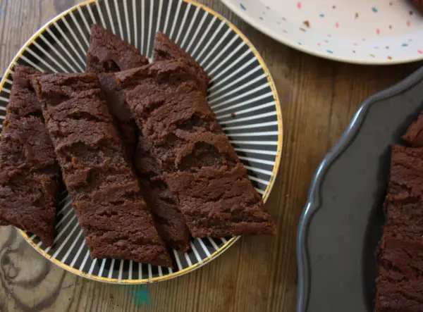 Chokladsnittar med flingsalt på en svartvitrandig tallrik. Dessa sega och rika chokladkakor är perfekta för fikat.